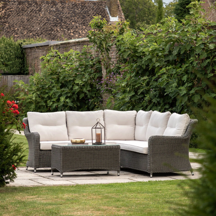 Stylish wicker outdoor corner sofa with plush grey cushions on a patio